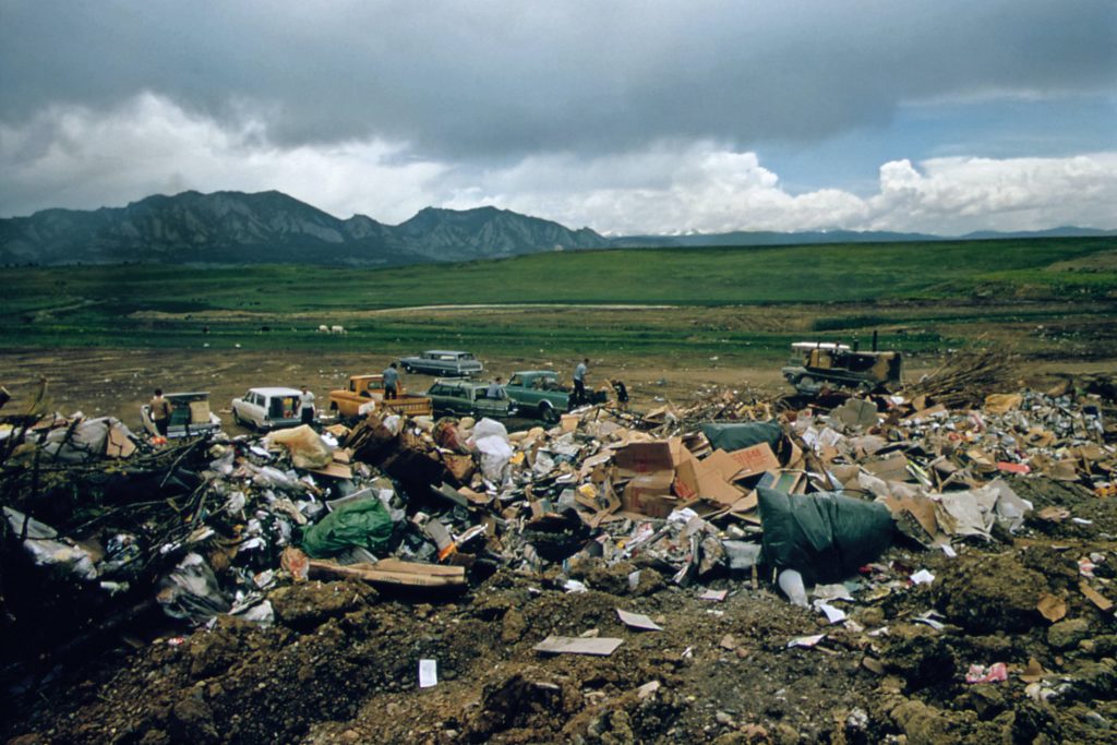A landfill of trash with a mountain range in the background.